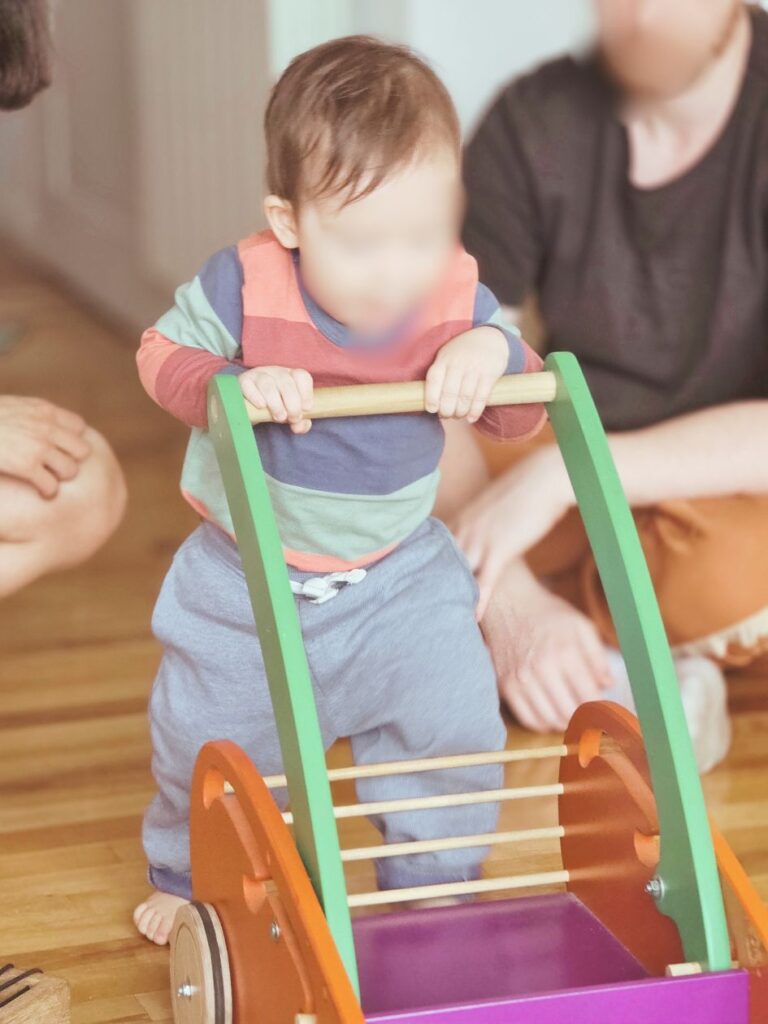 Bebé empujando carro de empuje en un espacio de juego libre.