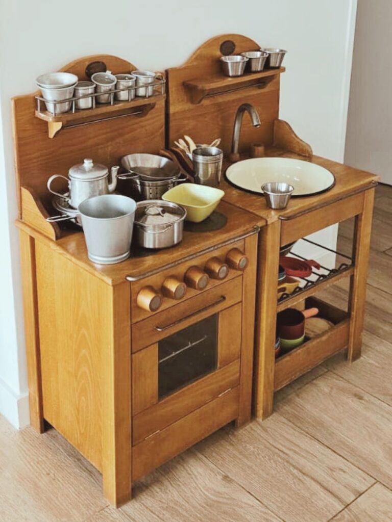 Cocinita de madera con vajilla de la marca Moulin Roty en espacio de juego libre