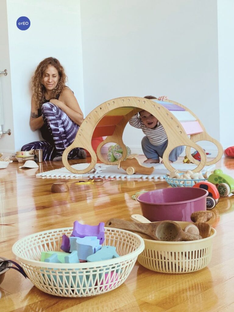 Bebé debajo de la hamaca balancín en un grupo de juego libre