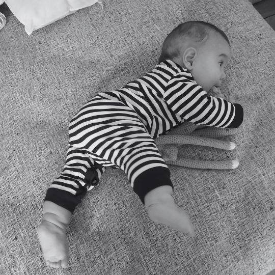 Bebé explorando su cuerpo en el piso a través del movimiento libre y el apoyo sobre distintas partes del cuerpo.