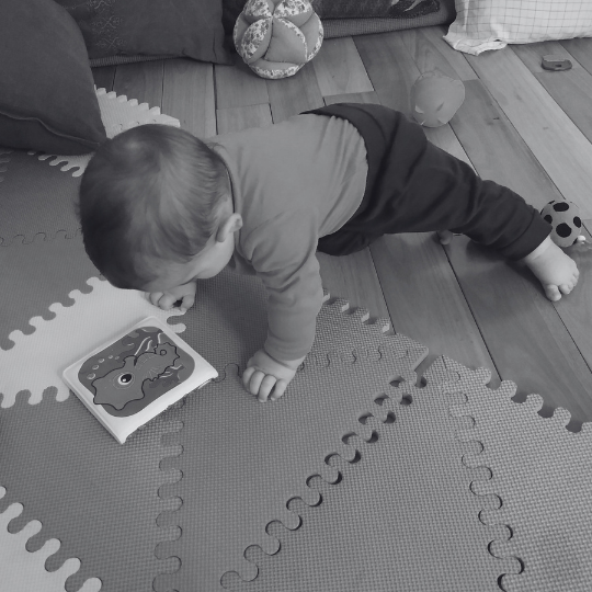 Bebé apoyado en manos y pies explorando el entorno desde el movimiento libre.