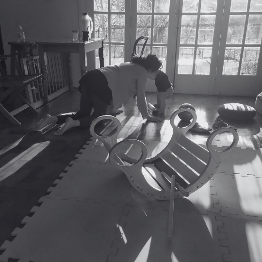 Adulto ofreciendo presencia corporal a un bebé durante su exploración en el piso.