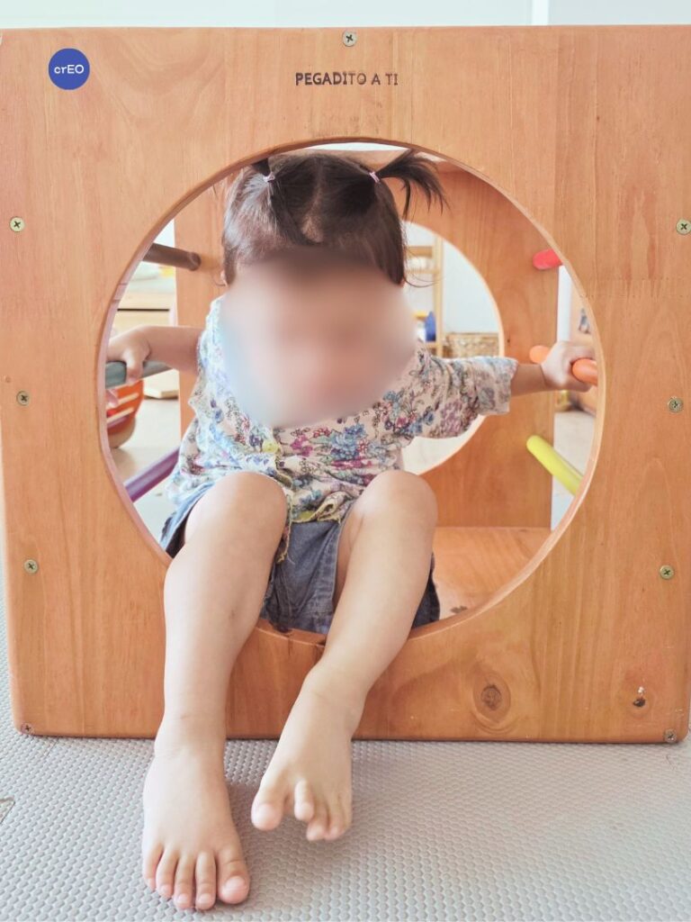 Bebé adentro del cubo Pikler en un grupo de juego libre