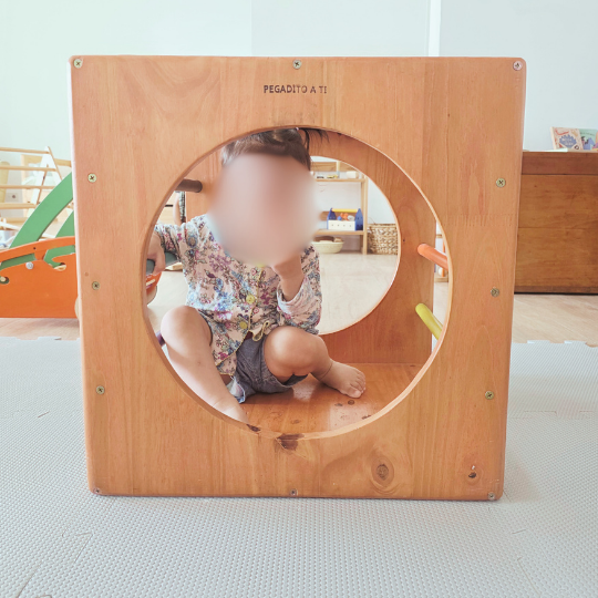 Bebé adentro del cubo Pikler en un grupo de juego libre