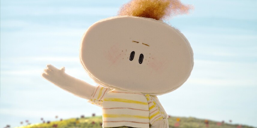 Escena del cortometraje stop motion The Kite con un niño y su abuelo volando una cometa.